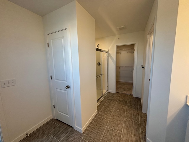 corridor featuring visible vents, wood tiled floor, and baseboards