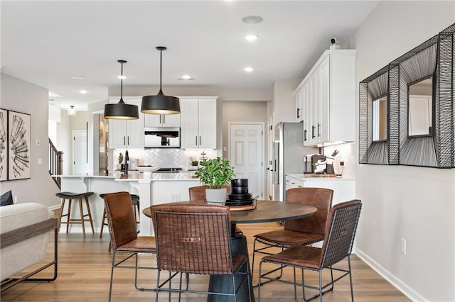 dining space featuring recessed lighting, light wood-style flooring, and baseboards