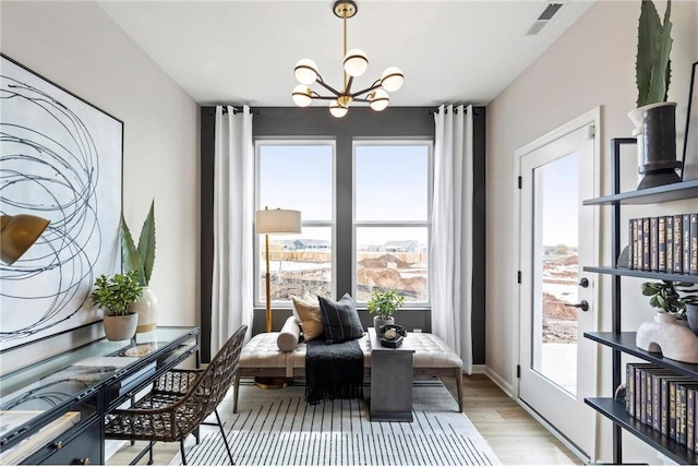 dining room featuring light wood-type flooring, an inviting chandelier, baseboards, and visible vents