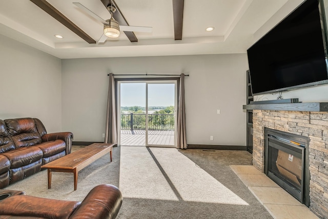 living room featuring a fireplace, light colored carpet, and ceiling fan