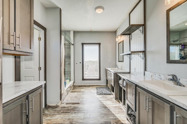 bathroom featuring an enclosed shower, vanity, and wood-type flooring