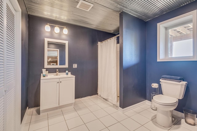 bathroom featuring tile patterned flooring, vanity, a shower with shower curtain, and toilet