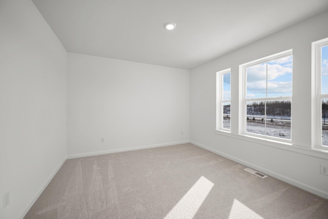 empty room with light colored carpet, visible vents, baseboards, and recessed lighting