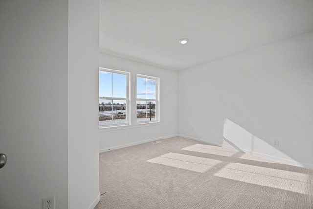 spare room with light carpet, baseboards, and recessed lighting