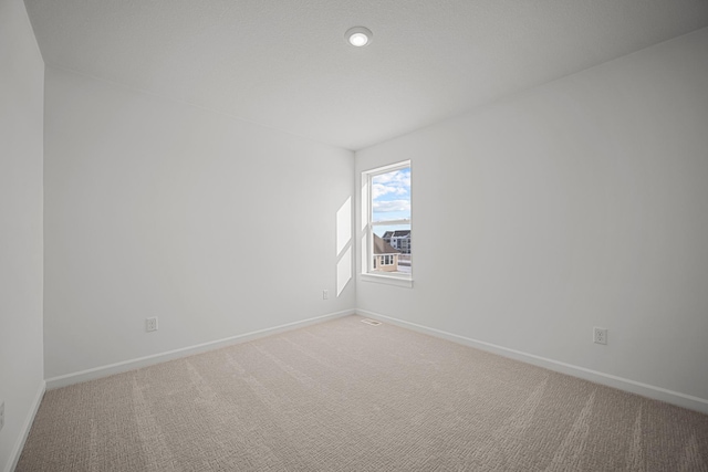 unfurnished room with carpet and baseboards