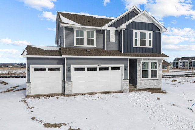 craftsman-style home with board and batten siding, stone siding, roof with shingles, and a garage