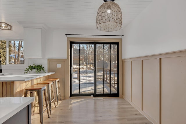 dining area with a healthy amount of sunlight, sink, wood ceiling, and light hardwood / wood-style flooring