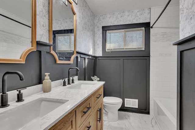 full bathroom with vanity, tiled shower / bath, and toilet