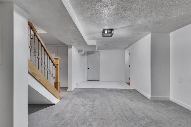 interior space featuring light carpet and a textured ceiling