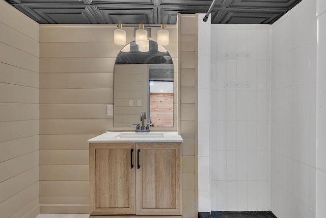 bathroom with vanity and wood walls