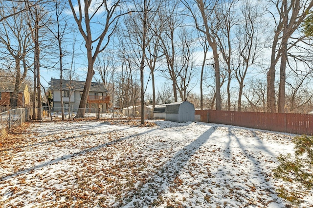 yard covered in snow featuring a storage unit