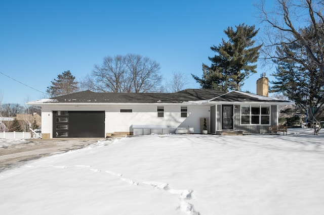 view of front of property with entry steps, a chimney, and an attached garage