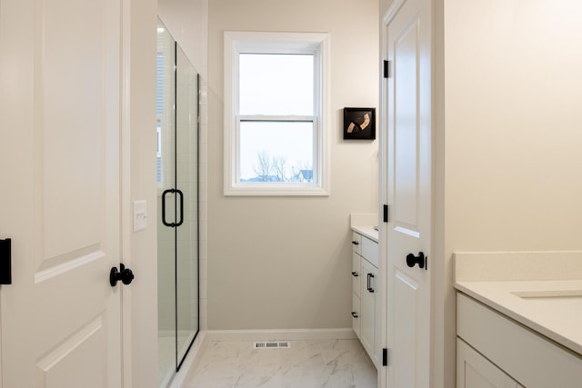 full bathroom with marble finish floor, visible vents, a stall shower, vanity, and baseboards