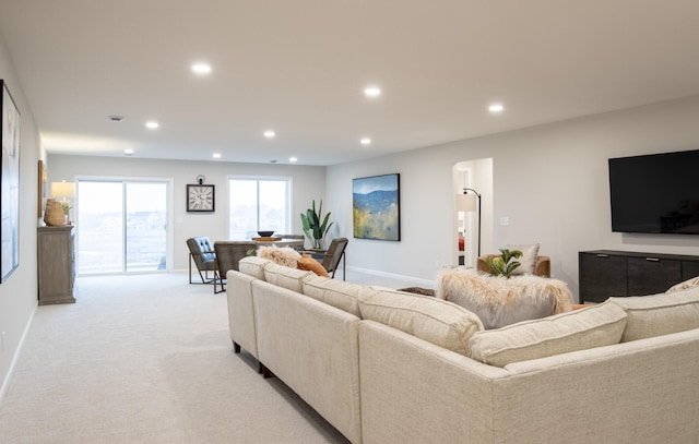 living area with recessed lighting, light carpet, and baseboards