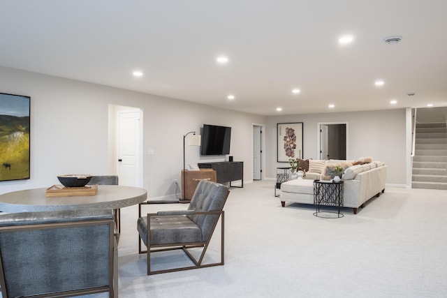 living area featuring recessed lighting, light carpet, baseboards, and stairs