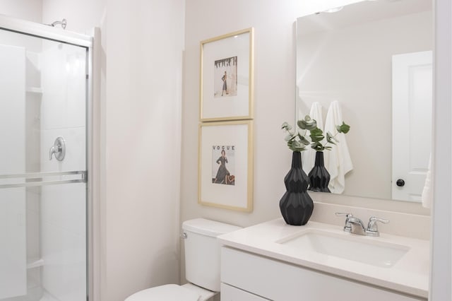 full bathroom with toilet, a stall shower, and vanity