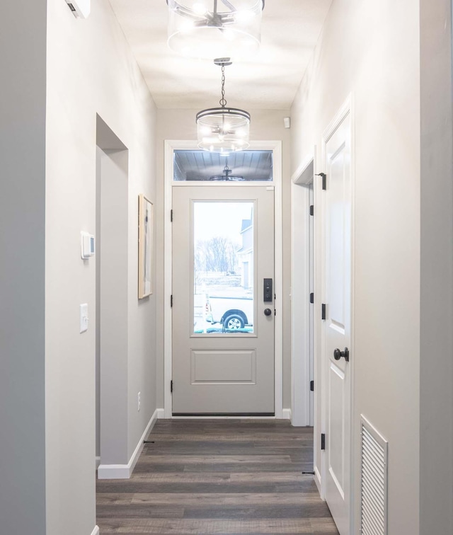 entryway with baseboards, visible vents, and dark wood-style flooring