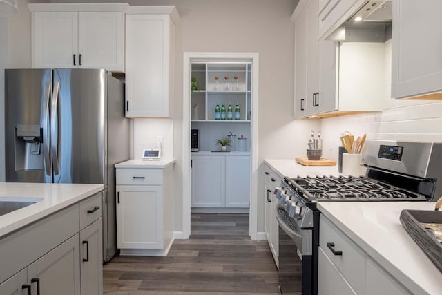 kitchen with light countertops, appliances with stainless steel finishes, white cabinetry, and under cabinet range hood