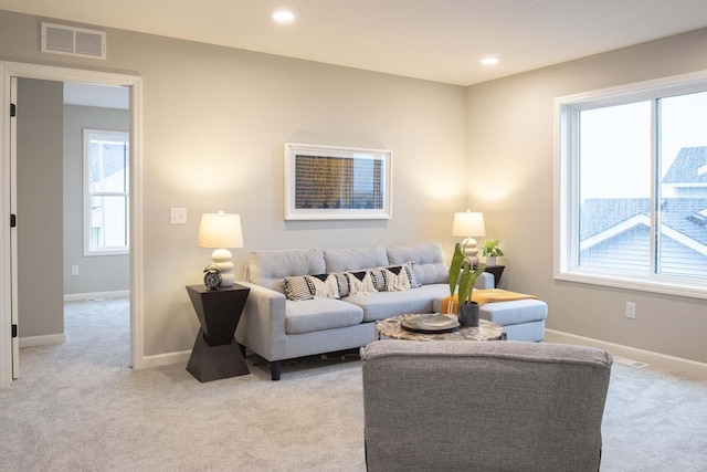 living area with light carpet, recessed lighting, visible vents, and baseboards