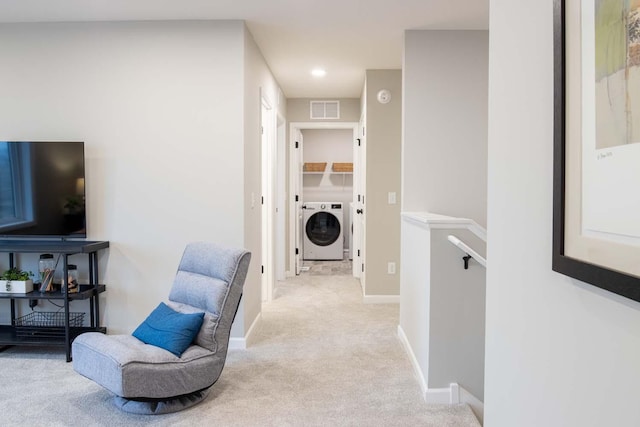 living area featuring light colored carpet, separate washer and dryer, an upstairs landing, baseboards, and visible vents