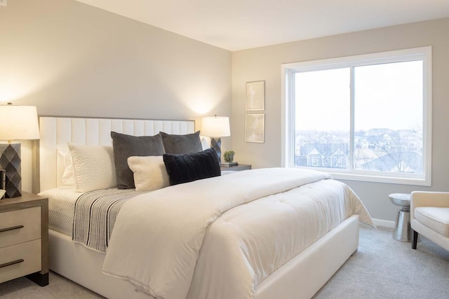 bedroom with light carpet and baseboards