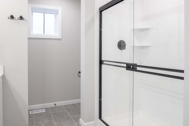 bathroom featuring a stall shower, visible vents, baseboards, and tile patterned floors