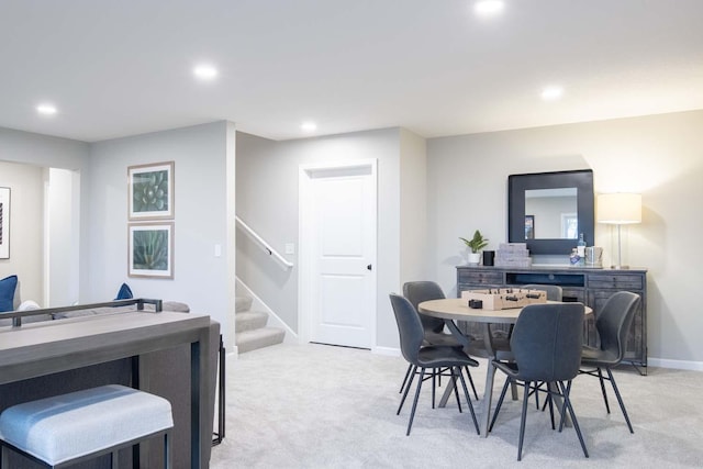 dining room featuring recessed lighting, stairs, baseboards, and light colored carpet