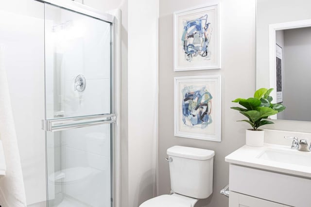 bathroom featuring a stall shower, vanity, and toilet