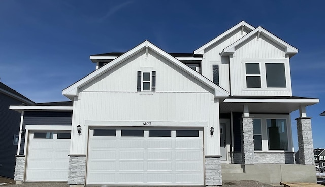 view of front of house featuring a garage, stone siding, and covered porch