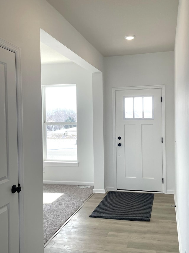 doorway featuring light wood-style floors and baseboards