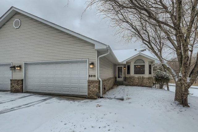 snow covered property featuring a garage