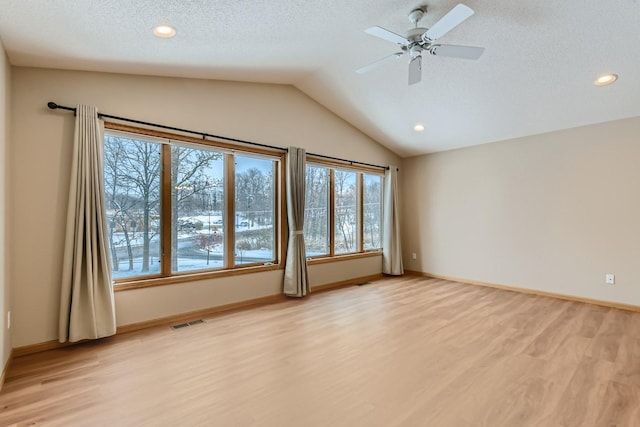 interior space featuring vaulted ceiling, ceiling fan, a textured ceiling, and light hardwood / wood-style flooring