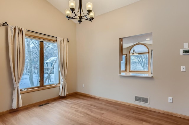 empty room with an inviting chandelier, baseboards, visible vents, and light wood-type flooring