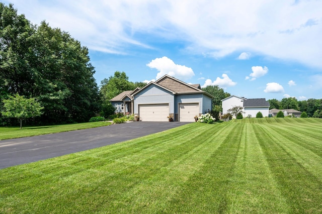 view of front of home with a garage, aphalt driveway, and a front yard