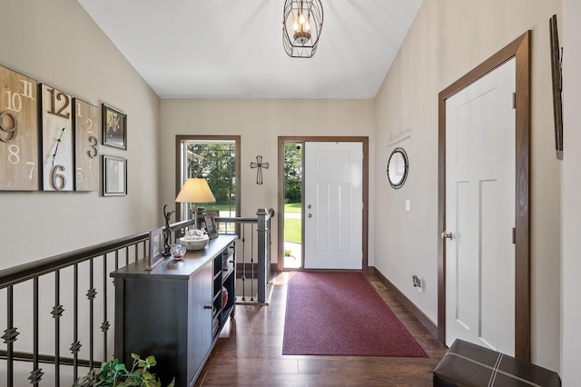 foyer featuring dark wood finished floors and baseboards