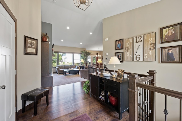 hall featuring high vaulted ceiling, wood finished floors, an upstairs landing, and recessed lighting