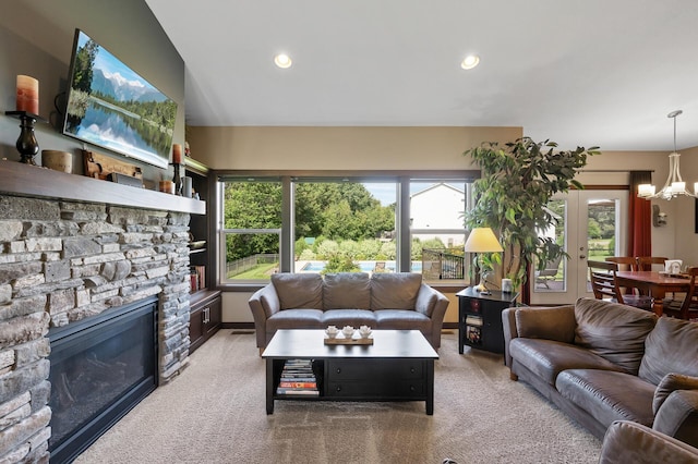 living room featuring carpet floors, recessed lighting, a fireplace, and an inviting chandelier