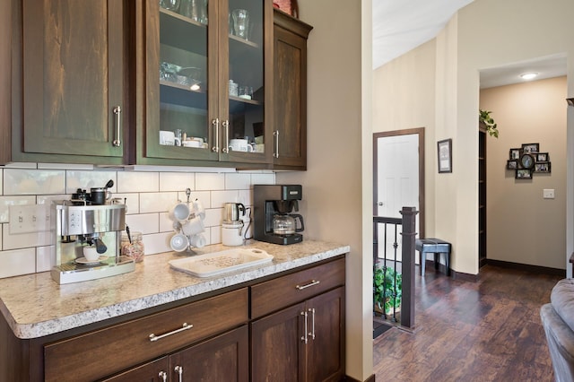 bar featuring baseboards, dark wood-type flooring, and decorative backsplash