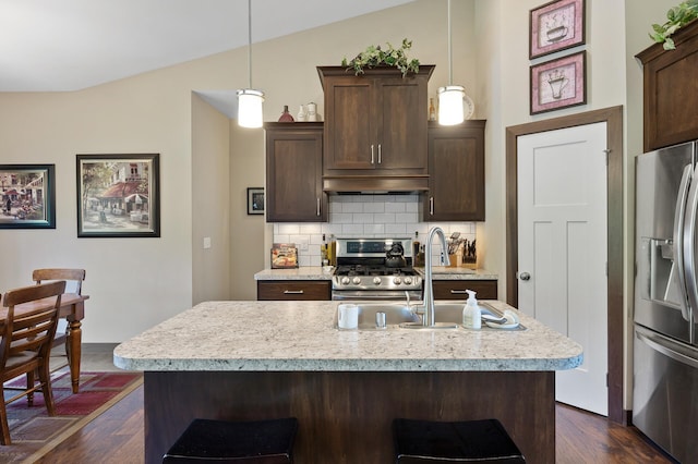 kitchen featuring tasteful backsplash, light countertops, appliances with stainless steel finishes, dark wood-type flooring, and extractor fan