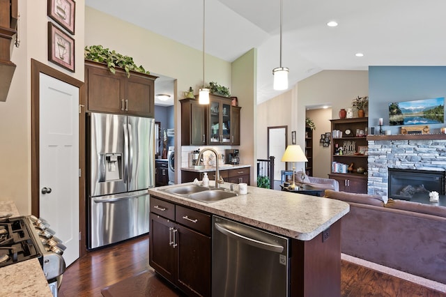 kitchen featuring stainless steel appliances, dark wood-type flooring, vaulted ceiling, a sink, and dark brown cabinetry