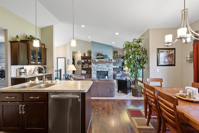 kitchen featuring washer / dryer, dark wood-style floors, a sink, light countertops, and stainless steel dishwasher