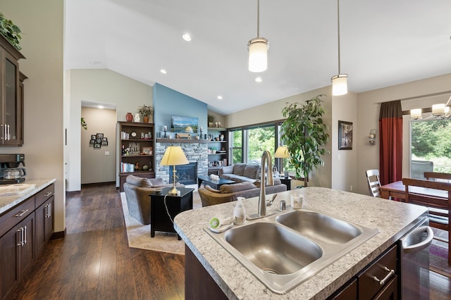 kitchen featuring dark wood-style floors, hanging light fixtures, vaulted ceiling, a sink, and dark brown cabinets