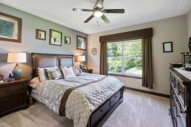 bedroom featuring ornamental molding, light colored carpet, ceiling fan, and baseboards