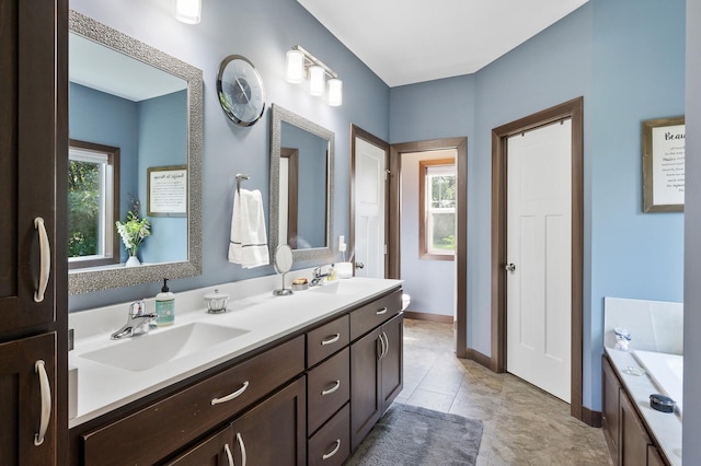 bathroom featuring double vanity, a sink, and a wealth of natural light