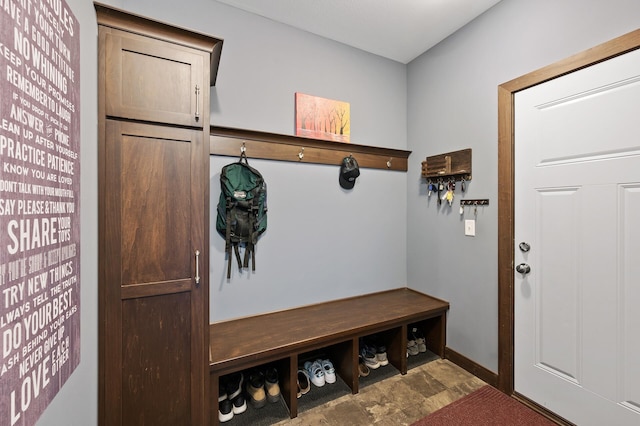 mudroom featuring stone finish flooring and baseboards