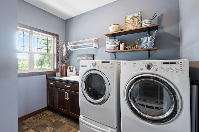 clothes washing area featuring visible vents, baseboards, cabinet space, stone finish flooring, and washer and clothes dryer