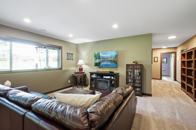 living room featuring recessed lighting, light colored carpet, a glass covered fireplace, and baseboards