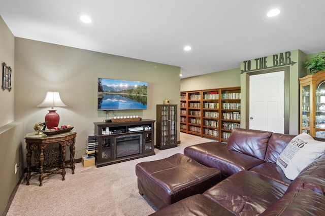 living room with carpet, a glass covered fireplace, baseboards, and recessed lighting