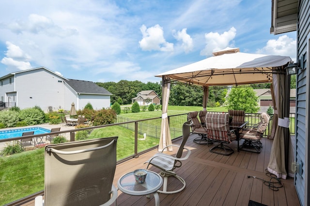 wooden terrace with a yard, outdoor dining space, a gazebo, and an outdoor pool