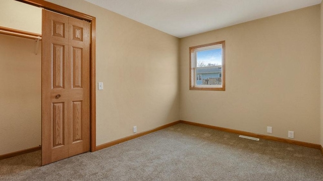 spare room featuring light colored carpet